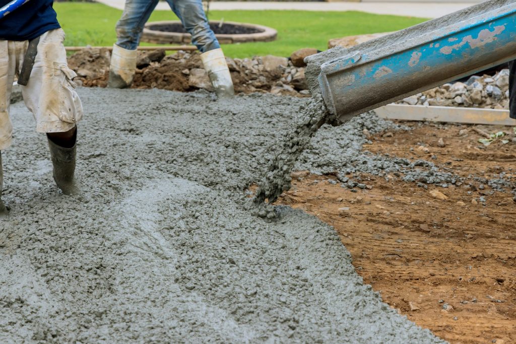 Paving a driveway on a construction site while pouring wet concrete